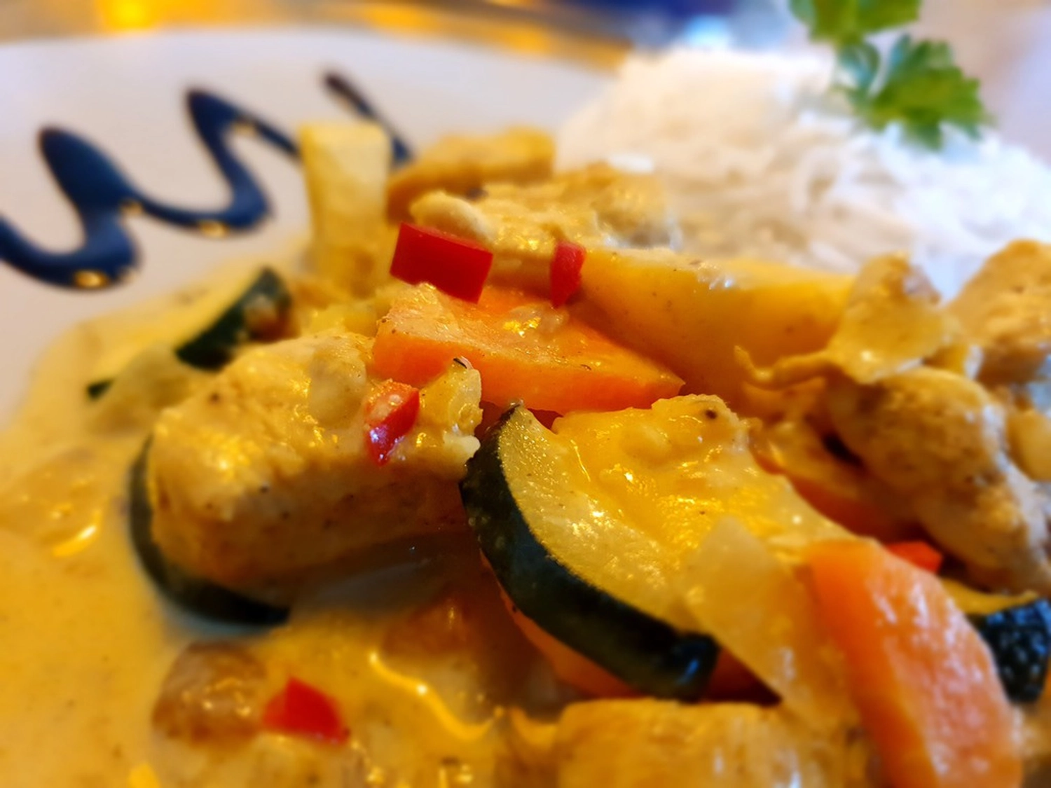 KochBAR Emsdetten – Kochstudio – Dieses Gericht ist ein Thai-Curry, wahrscheinlich ein grünes oder rotes Hühnercurry, erkennbar an der cremigen Kokosmilchbasis und den leuchtenden Farben.
