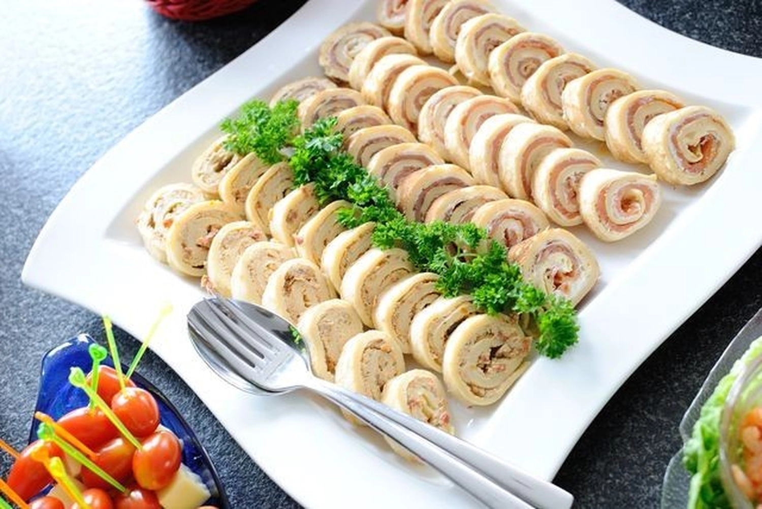 KochBAR Emsdetten – Kochstudio – Das Bild zeigt eine große Platte mit Pinwheel-Sandwiches, einem beliebten Fingerfood, das oft als Vorspeise bei Feiern serviert wird.