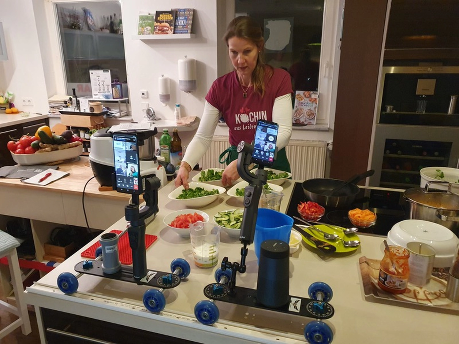 KochBAR Emsdetten – Kochstudio – Dieses Bild zeigt offenbar einen virtuellen Kochkurs oder eine Live-Übertragung einer Kochvorführung aus einer privaten Küche.