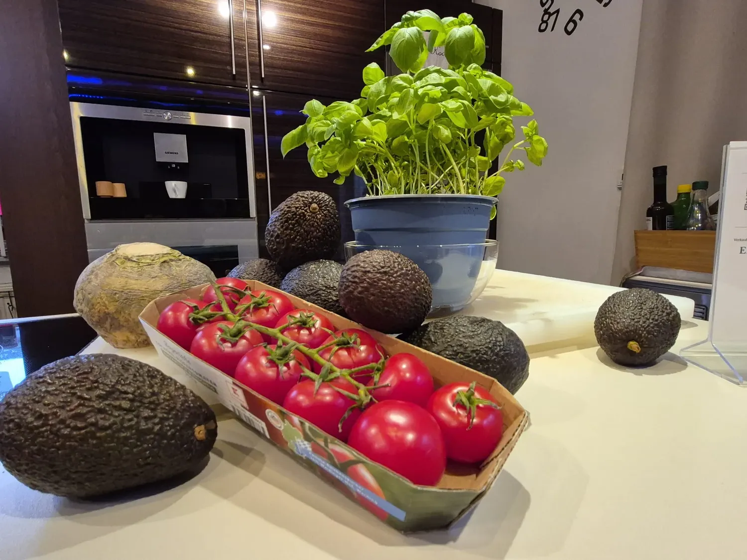 KochBAR Emsdetten – Kochstudio – Dieses Bild zeigt frische Zutaten für Guacamole, vor allem mehrere Avocados und eine Handvoll Strauchtomaten.